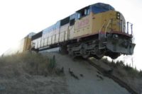 Witzbild: Lokomotive hängt über einer Düne in der Luft