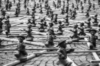 Sschwarz-weiß-Foto einer Installation zum Tag der deutschen Einheit. auf Latten montiert sind viele (Hunderte?) etwa kniehohe Figuren des alten "Ampelmännchens" der Fußgängerampeln der DDR. Die Männchen "laufen" in lockerem Abstand in alle Richtungen durcheinander. Das Bild zeigt im Vordergrund ein paar der Männchen in Großaufnahme scharf, im Hintergrund erstreckt sich die Masse unschärfer werdend bis zum Horizont