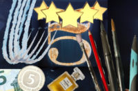Collage aus verschiedenen Symbolen für fünf: Stück eines 5-Euro-Scheins, 5-Mark-Münze, 5 Sterne, große Ziffer 5 in Goldfarbe, Kunstflugstaffel aus fünf Flugzeugen, eine Flasche Chanel No. 5 und fünf Werkzeuge: Borstenpinsel, Buntstift, Füller, Haarpinsel und Kugelschreiber