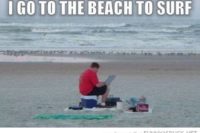 Witzbild. Text oben "I go to the beach to surf". Auf dem Foto selbst sitzt ein Mann am Strand. Auf einer Kühlbox, Strandutensilien um ihn ausgebreitet, und hat auf seinem Schoß ein Laptop und guckt konzentriert drauf.