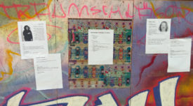 Seitenwand der Kunsthaltestelle/Miniaturkino, dekoriert mit Graffiti und Straßenfest-Plakaten, darauf verteilt Info-Blätter zum Kinoprogramm über alle Filme und die Filmemacher