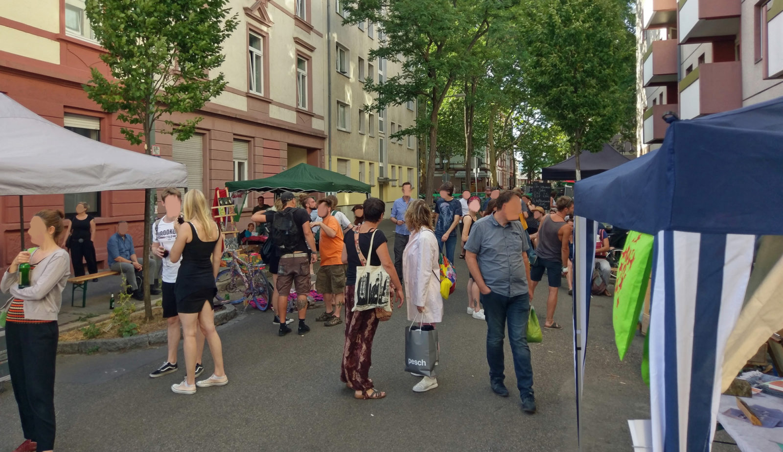 Totale über die Straße, am Rand Schirme und Pavillons der Stände, in der Mitte Besucher, das Fest ist gut gefüllt