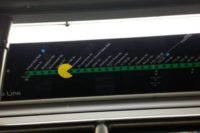 U-Bahn-Linienplan. Auf der schematisch dargestellten Linie mit den Haltepunkten hat jemand einen Pacman aufgeklebt, der die Bahnhöfe zu fressen scheint.
