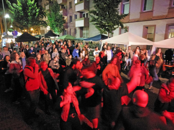 Blick ins Publikum, das sich weit nach hinten staut und vor der Bühne viele tanzende Zuhörer