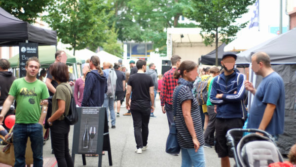 Blick durch die 'Kunstmeile' Richtung Bühne mit Publikum, das das Fest bevölkert