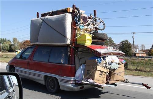 Spaßfoto: Ein Van, schon an sich nicht klein, aber beladen weit über das Fahrzeug hinaus. Matratzen und Fahrräder auf dem Dach, aus dem Kofferraum ragen Längsträger, auf denen Kartons stehen... (die Kneipe, wo wir uns treffen, ist umgezogen, deswegen ;-) )