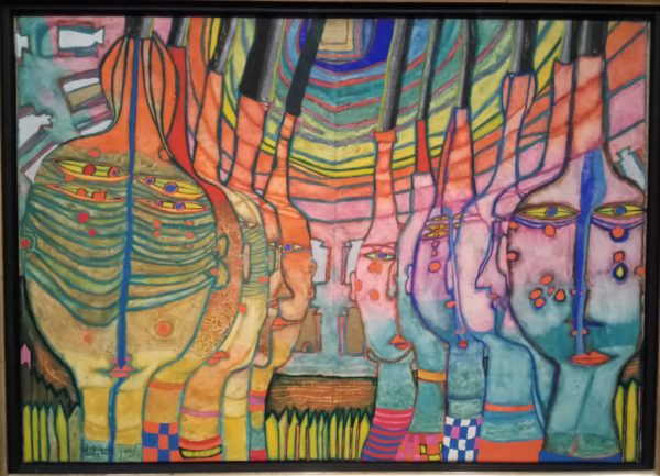 Bild von Friedensreich Hundertwasser. in den für ihn typischen bunten Farben scheinen am ehesten Köpfe dargestellt. auf der linken Bildhälfte in Gelb- und Grüntönen und vom Betrachter abgewandt, auf der rechten Seite in lila und blau und zum Betrachter hinsehend. (Original selbst fotografiert im Buchheim Museum, Bernried)